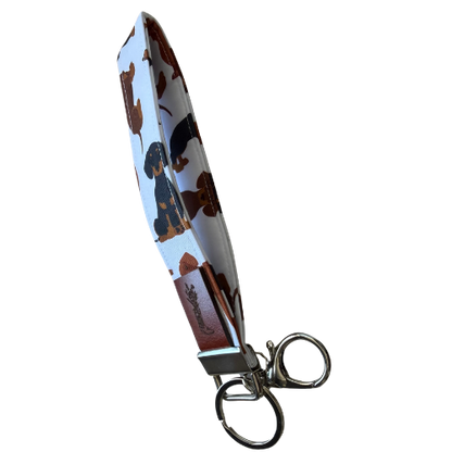 A fabric keychain pouch with a dachshund pattern, featuring a silver metal key ring and clasp, shown on a plain white background.